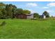 A large grass-covered yard with a brick home and storage container under a bright blue sky at 2074 W 300 S, Shelbyville, IN 46176