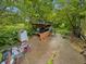 Outdoor patio area with furniture and various objects, surrounded by lush greenery at 2074 W 300 S, Shelbyville, IN 46176