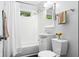 Bright bathroom features tiled walls, a shower-tub combo, vanity with storage, and a modern toilet at 2233 Washington St, Columbus, IN 47201