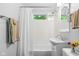 Bright bathroom features tiled walls, a shower-tub combo, vanity with storage, and a modern toilet at 2233 Washington St, Columbus, IN 47201