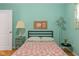 Cozy bedroom boasts wood floors, aqua walls, a floral comforter, and natural light from the windows at 2233 Washington St, Columbus, IN 47201