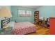 Bright bedroom with floral comforter, wood floors, and a desk area with a bookcase at 2233 Washington St, Columbus, IN 47201