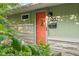Close-up of the green house exterior featuring a red door and well-kept front yard at 2233 Washington St, Columbus, IN 47201
