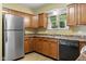 Functional kitchen with wood cabinetry, modern appliances, and a bright window, offering ample storage and natural light at 2233 Washington St, Columbus, IN 47201