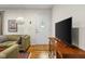 Cozy living room with hardwood floors, a sofa, TV, and a white front door at 2233 Washington St, Columbus, IN 47201