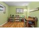 Room with hardwood floors, shelving, a desk, a green accent wall, and natural light at 2233 Washington St, Columbus, IN 47201