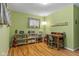 Room with hardwood floors, shelving, a desk, a green accent wall, and natural light at 2233 Washington St, Columbus, IN 47201