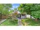 Charming home featuring a welcoming front porch with lovely landscaping and mature trees at 2433 E 16Th St, Indianapolis, IN 46201