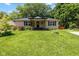 Charming single-story home featuring a covered porch, mature trees, and a lush green lawn at 29 Northview Dr, Danville, IN 46122