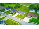 Street aerial view of well-manicured lawns and dark roofed homes with driveways and green trees at 32 Downing Dr, Trafalgar, IN 46181