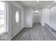 Welcoming entryway with wood-look flooring and ample natural light, showcasing a seamless transition into the home at 32 Downing Dr, Trafalgar, IN 46181