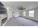 Open floor plan showcases the living room with a stone fireplace and neutral carpet at 32 Downing Dr, Trafalgar, IN 46181
