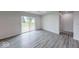 Spacious room with natural light and wood-style gray floors, access to outdoor deck at 32 Downing Dr, Trafalgar, IN 46181
