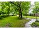 Lush backyard with green grass, mature trees, and a visible pathway at 3652 N Kenwood Ave, Indianapolis, IN 46208