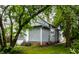 Home exterior with light-gray siding framed by mature trees and a well-kept lawn at 3652 N Kenwood Ave, Indianapolis, IN 46208