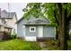 Home exterior featuring gray siding with neat landscaping and mature trees at 3652 N Kenwood Ave, Indianapolis, IN 46208