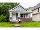 Charming bungalow with a brick-accented porch and fresh gray siding, located in a residential area at 3652 N Kenwood Ave, Indianapolis, IN 46208