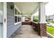 Spacious front porch with brick detailing, gray siding, offering ample space to relax and enjoy outdoors at 3652 N Kenwood Ave, Indianapolis, IN 46208