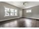Spacious living room with large windows for natural light, ceiling fan and new flooring at 3652 N Kenwood Ave, Indianapolis, IN 46208