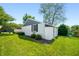 Beautiful backyard with a white brick home, green lawn, and mature trees at 3701 Sandy Hook Dr, Columbus, IN 47203