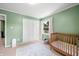 Charming Bedroom with green walls, natural light, and a crib at 3701 Sandy Hook Dr, Columbus, IN 47203