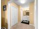 Hallway leading to an ensuite bathroom featuring white cabinets and black and white tile at 3701 Sandy Hook Dr, Columbus, IN 47203