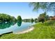 Picturesque waterfront view with lush green lawn leading to a tranquil lake and sandy beach at 3701 Sandy Hook Dr, Columbus, IN 47203