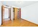 Bright bedroom with hardwood floors, closet with sliding doors, and shelving at 4733 E 100 S, Anderson, IN 46017