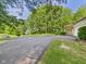 Paved driveway leading to a home surrounded by mature trees and landscaping at 4733 E 100 S, Anderson, IN 46017
