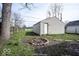 Backyard with outdoor fire pit next to detached garage and a wooden fence at 5050 W Regent St, Indianapolis, IN 46241