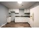 Well-lit kitchen featuring white cabinets, laminate counters, and wood-look vinyl flooring at 5050 W Regent St, Indianapolis, IN 46241