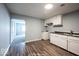 Cozy kitchen featuring wood-look flooring, white cabinets, and sleek countertops at 5050 W Regent St, Indianapolis, IN 46241