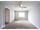 Bright living room with carpet flooring, a ceiling fan, and a large window for natural light at 5050 W Regent St, Indianapolis, IN 46241