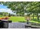 Expansive backyard featuring patio, storage shed, and mature trees on a sunny day at 5215 Limestone Ct, Indianapolis, IN 46237