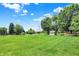 Backyard with large lawn featuring a shed, white arbor and a landscape area under a blue sky at 5215 Limestone Ct, Indianapolis, IN 46237