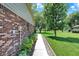Brick home exterior featuring a concrete walkway bordered by landscaping and leading to a well-maintained lawn at 5215 Limestone Ct, Indianapolis, IN 46237