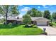 Single-story brick home with a two-car garage, a well-maintained lawn, landscaping, and mature trees in a suburban neighborhood at 5215 Limestone Ct, Indianapolis, IN 46237