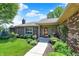 Inviting brick home features a red front door and charming landscaped front porch at 5215 Limestone Ct, Indianapolis, IN 46237