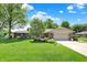 Ranch-style brick home with well-manicured lawn, mature trees, and attached two car garage at 5215 Limestone Ct, Indianapolis, IN 46237