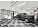 Spacious garage featuring storage cabinets, black truck, and black and gray checkerboard flooring at 5215 Limestone Ct, Indianapolis, IN 46237