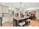 Stylish kitchen boasts an island, stainless appliances, granite countertops, and white cabinets, open to dining area at 5215 Limestone Ct, Indianapolis, IN 46237