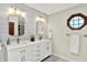 An elegant primary bathroom offers double sinks, modern lighting, and a unique octagon-shaped window at 5215 Limestone Ct, Indianapolis, IN 46237