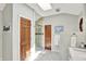 A well-lit primary bathroom hall with a glass door shower stall, and tile flooring at 5215 Limestone Ct, Indianapolis, IN 46237