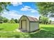 Backyard shed with roll up door and a barn roof design, surrounded by a lush green lawn at 5215 Limestone Ct, Indianapolis, IN 46237