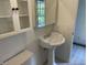 Clean bathroom featuring a pedestal sink, medicine cabinet, and white tile flooring at 526 Emerson Rd, Carmel, IN 46032