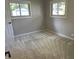 A simple, carpeted bedroom with two windows offering natural light and neutral-colored walls at 526 Emerson Rd, Carmel, IN 46032