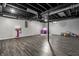 Spacious basement rec room with open ceiling, wood-look flooring, and play area at 608 E 9Th St, Indianapolis, IN 46202