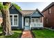 Charming blue home featuring a quaint front porch, manicured lawn, and a classic brick walkway at 608 E 9Th St, Indianapolis, IN 46202