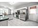 Open kitchen with stainless steel appliances, white cabinets, and an eat-in area at 608 E 9Th St, Indianapolis, IN 46202