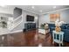 Open-concept living room featuring hardwood floors, a blue sofa, and a modern TV console at 608 E 9Th St, Indianapolis, IN 46202